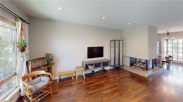 interior space with a healthy amount of sunlight, dark hardwood / wood-style floors, and a notable chandelier