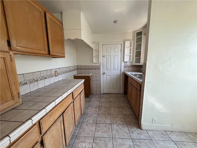 4419 Radium Dr, Los Angeles, CA 90032 - kitchen featuring tile counters, glass insert cabinets, and light tile patterned floors