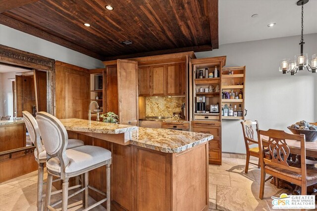 kitchen featuring pendant lighting, light stone counters, wooden ceiling, and backsplash