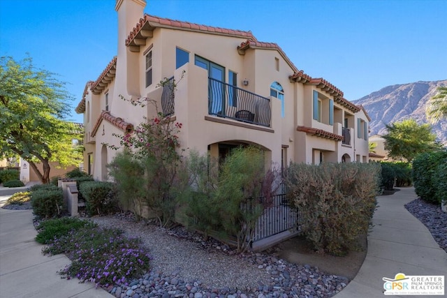 view of home's exterior featuring a mountain view and a balcony