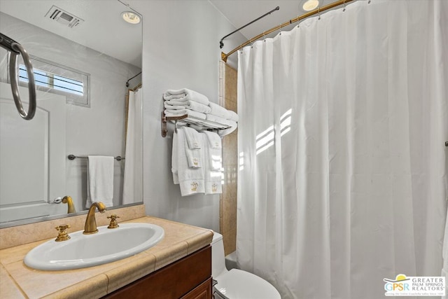 full bathroom featuring vanity, shower / bath combo, and toilet