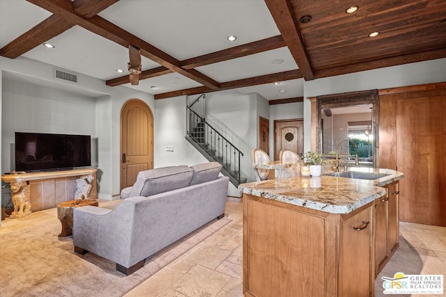 living room featuring beamed ceiling, ceiling fan, coffered ceiling, and sink