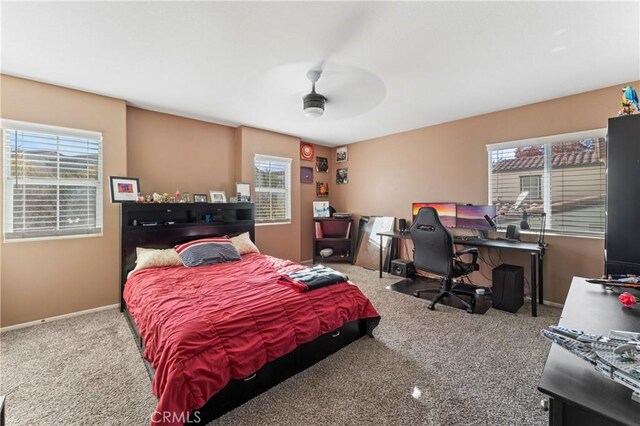 bedroom with a ceiling fan, carpet flooring, and baseboards