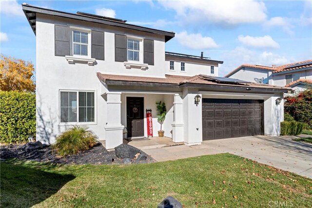 traditional home with a front lawn, a garage, driveway, solar panels, and stucco siding