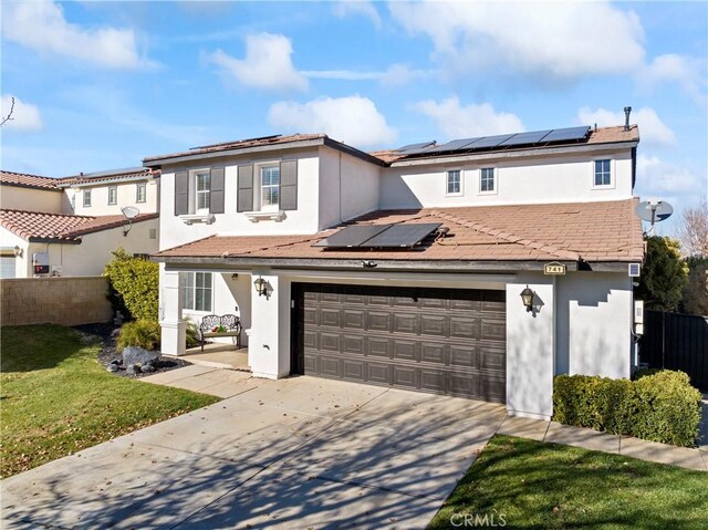 view of front facade with stucco siding, fence, solar panels, a front lawn, and concrete driveway