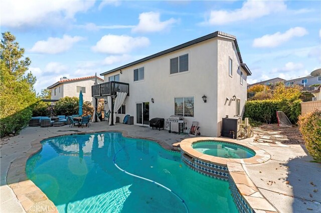 view of swimming pool featuring a patio, a pool with connected hot tub, and fence