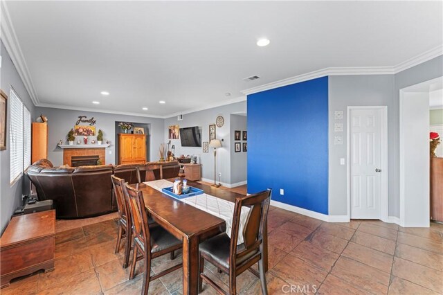 dining space featuring baseboards, recessed lighting, crown molding, and a fireplace