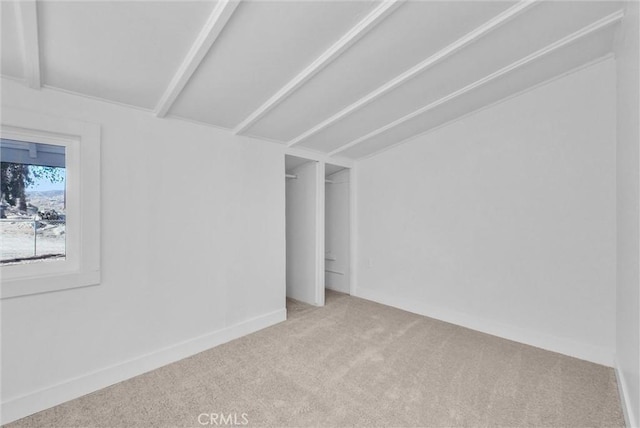 interior space featuring carpet and vaulted ceiling with beams