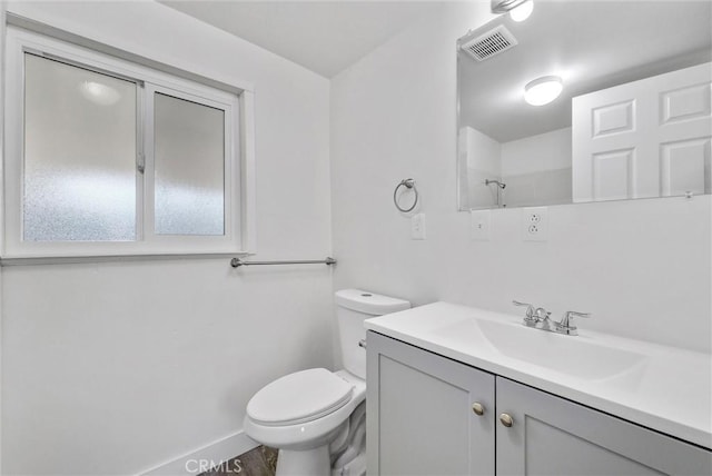 bathroom featuring vanity, toilet, and walk in shower