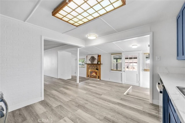 interior space with brick wall and light hardwood / wood-style flooring