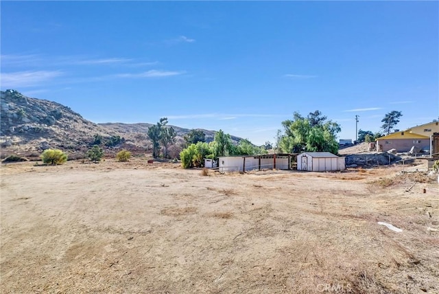 view of yard featuring a mountain view and a storage unit