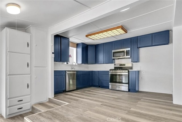 kitchen with sink, blue cabinets, and stainless steel appliances