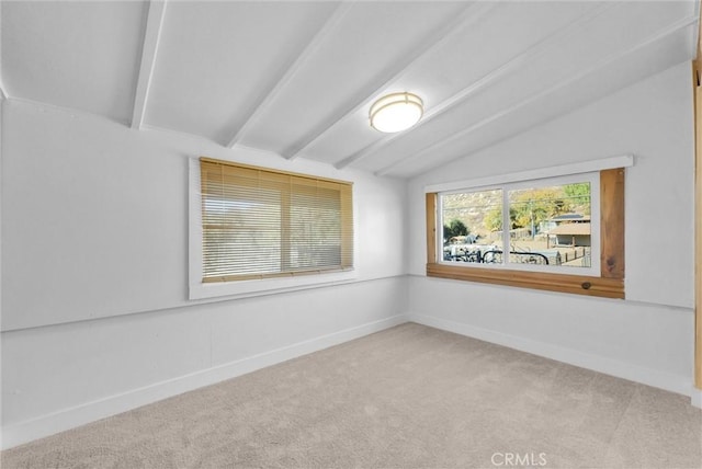 carpeted spare room featuring vaulted ceiling with beams