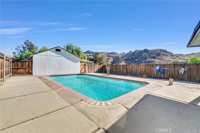 view of pool with a mountain view and a patio