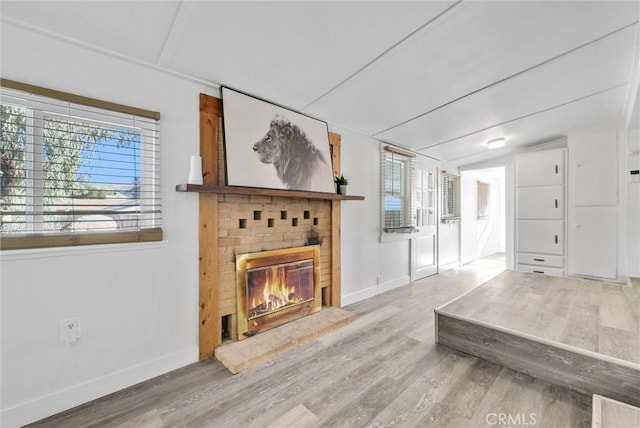 living room with a fireplace, wood-type flooring, and vaulted ceiling