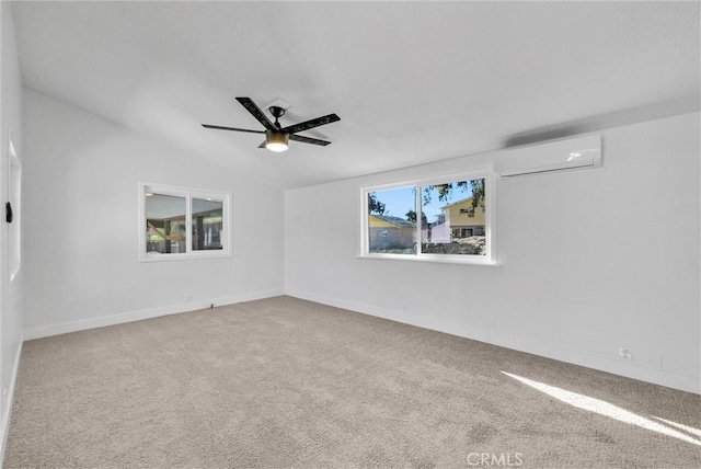 unfurnished room with ceiling fan, an AC wall unit, a wealth of natural light, and vaulted ceiling