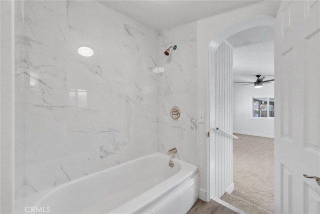 bathroom featuring ceiling fan, tiled shower / bath combo, and hardwood / wood-style flooring