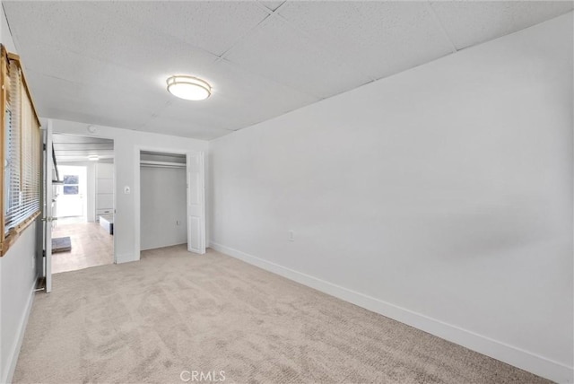 unfurnished bedroom with light carpet and a closet