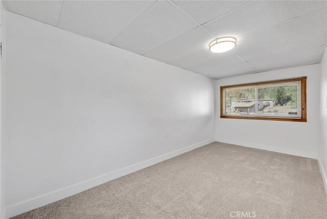 spare room with carpet flooring and a drop ceiling