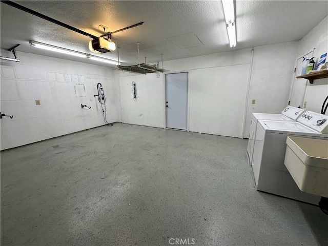 garage with washer and dryer, a garage door opener, and sink