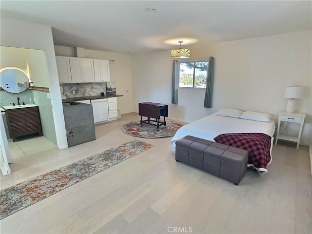 bedroom featuring light hardwood / wood-style floors and sink