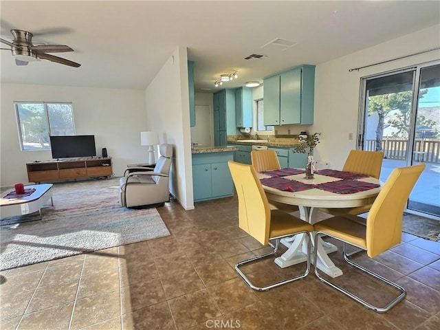 tiled dining area with ceiling fan and sink