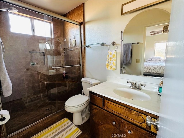 bathroom featuring vanity, toilet, and a shower with door