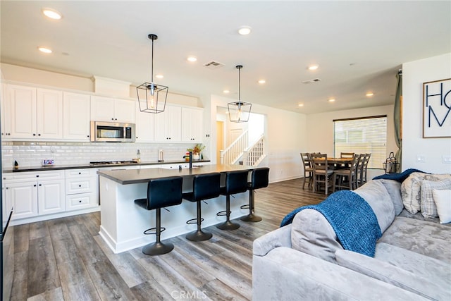 kitchen featuring white cabinetry, hanging light fixtures, and stainless steel appliances