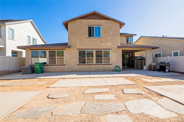 rear view of property with central AC unit and a patio area