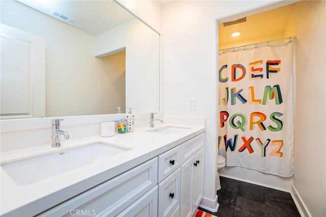 bathroom with tile patterned flooring, vanity, and toilet