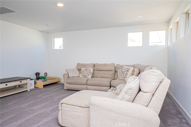 living room with dark colored carpet and plenty of natural light