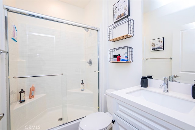 bathroom with vanity, a shower with shower door, and toilet