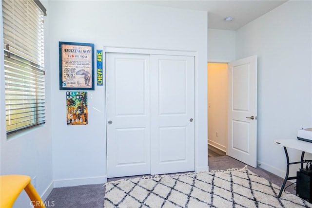 unfurnished bedroom with a closet and dark carpet