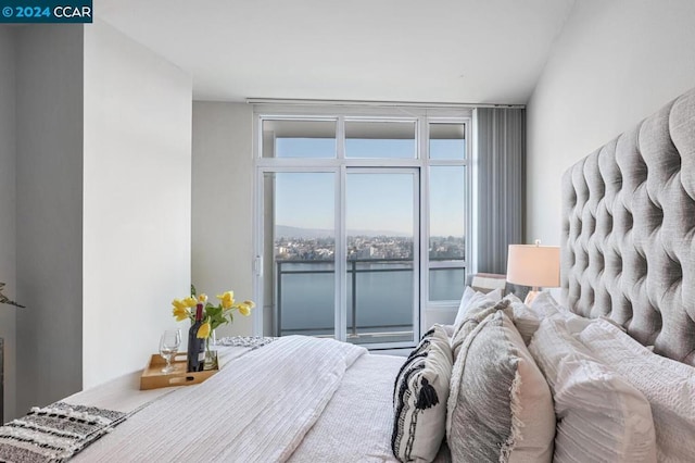 bedroom featuring access to outside and a water view