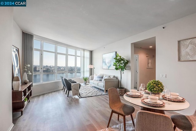 dining space featuring a water view and light hardwood / wood-style flooring