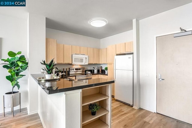 kitchen featuring light hardwood / wood-style floors, white appliances, kitchen peninsula, and light brown cabinetry