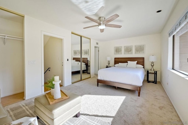 carpeted bedroom with two closets and ceiling fan