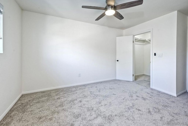 unfurnished bedroom featuring ceiling fan, light colored carpet, a spacious closet, and a closet