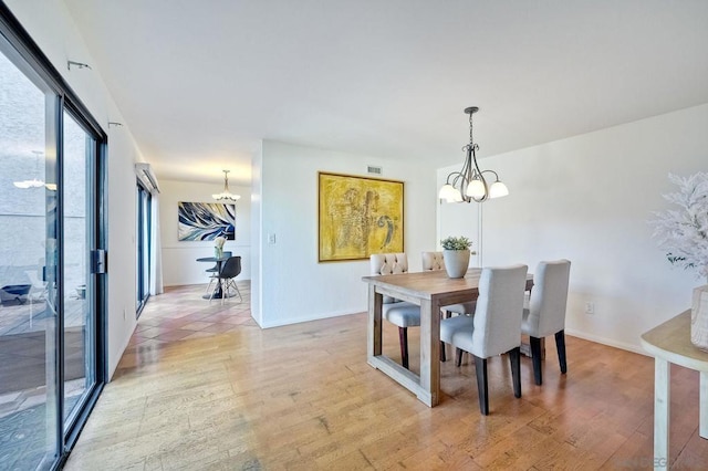 dining area featuring an inviting chandelier and light hardwood / wood-style flooring