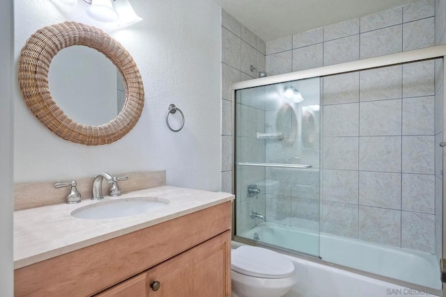 full bathroom featuring enclosed tub / shower combo, vanity, and toilet