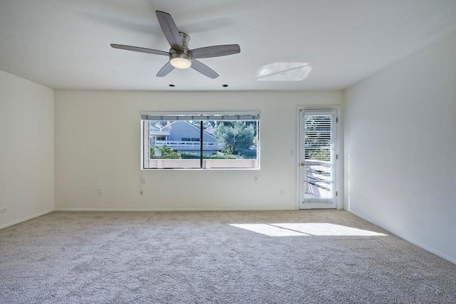 carpeted spare room featuring ceiling fan