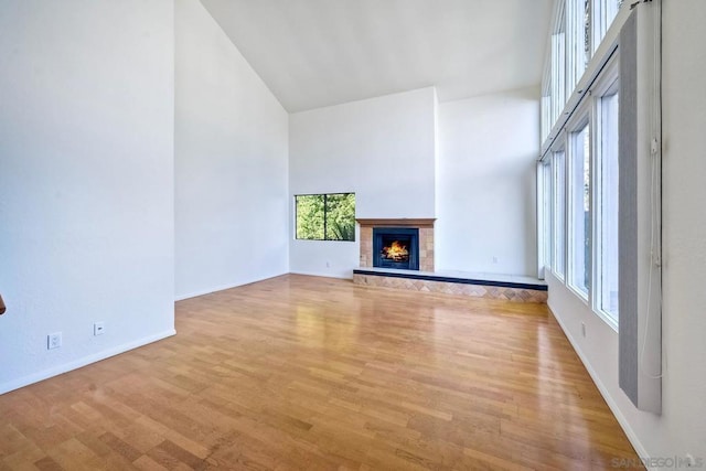 unfurnished living room featuring light hardwood / wood-style floors and a high ceiling