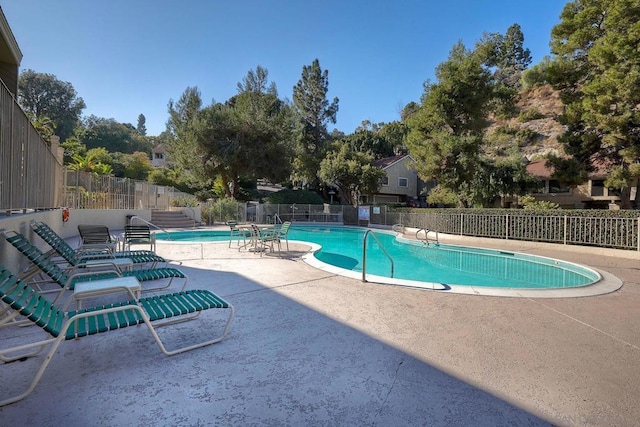 view of pool with a hot tub and a patio