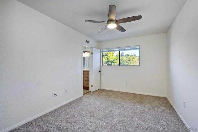 carpeted spare room featuring ceiling fan