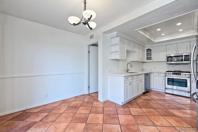 kitchen with sink, white cabinetry, decorative light fixtures, a raised ceiling, and stainless steel appliances