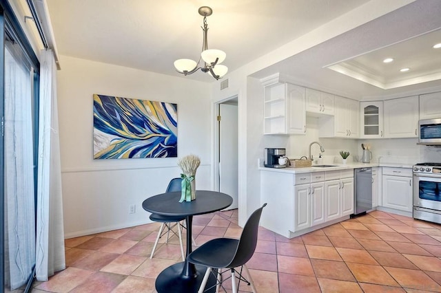 kitchen featuring decorative light fixtures, sink, white cabinets, a chandelier, and stainless steel appliances