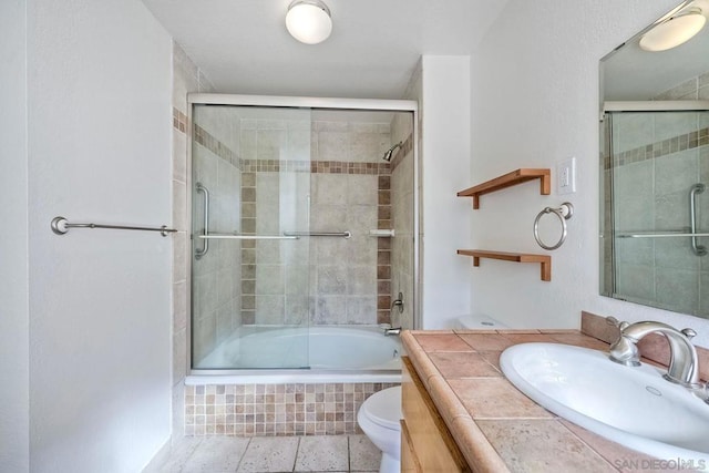 full bathroom featuring bath / shower combo with glass door, vanity, and toilet