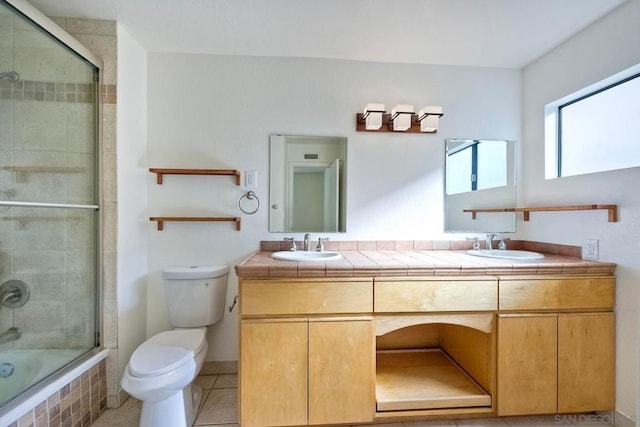 full bathroom with vanity, tile patterned floors, shower / bath combination with glass door, and toilet