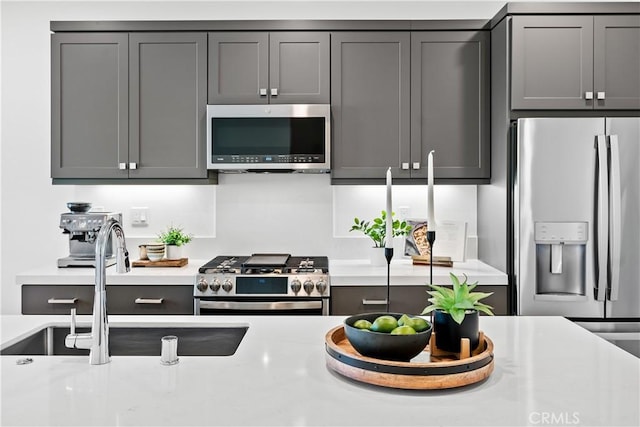 kitchen with sink, gray cabinets, and appliances with stainless steel finishes