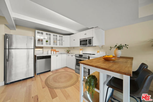 kitchen featuring light hardwood / wood-style flooring, white cabinets, and stainless steel appliances